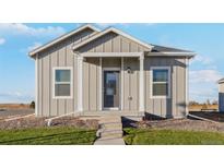 Modern farmhouse style home with gray siding at 2992 Oxley St, Strasburg, CO 80136