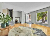Bright living room with hardwood floors, large window, and a cozy fireplace at 17769 E Iowa Dr, Aurora, CO 80017