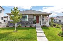 Modern two-story home with stone accents and a red door at 18000 E 100Th Ave, Commerce City, CO 80022