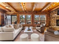 Cozy living room with stone fireplace and mountain views at 878 American Way, Breckenridge, CO 80424