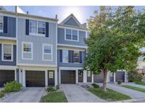 Gray townhome exterior with double-car garage and landscaping at 12008 E Tennessee Dr, Aurora, CO 80012