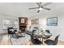 Bright living room with fireplace, dining area, and hardwood floors at 1100 S Waco St # G, Aurora, CO 80017