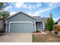 Ranch style home with gray exterior, attached garage, and mature landscaping at 4319 Dearborn St, Denver, CO 80239