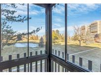 View from balcony showcases a green space with mature trees and nearby buildings at 13631 E Marina Dr # 107, Aurora, CO 80014