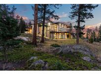 Luxury home nestled in the mountains, showcasing a stunning exterior at dusk at 1082 W Meadow Rd, Evergreen, CO 80439
