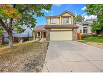 Two story house with a yellow exterior, two car garage and landscaping at 19873 E Vassar Ave, Aurora, CO 80013