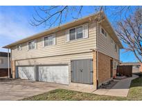 Brick triplex with three-car garage and landscaped grounds at 9747 Croke Dr, Denver, CO 80260