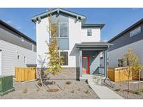 Two-story home with a gray and white exterior, red door, and landscaped yard at 6257 N Nepal Ct, Aurora, CO 80019