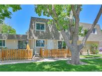 A charming townhome with a wooden fence and mature tree at 6885 E Arizona Avenue # D, Denver, CO 80224