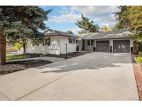 White ranch home with gray garage doors and landscaped yard at 2395 W Davies Ave, Littleton, CO 80120