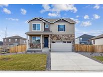 Two-story house with stone accents and a two-car garage at 13461 Valentia St, Thornton, CO 80602