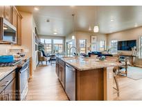 Open concept kitchen with island and granite countertops at 830 W 128Th Pl, Westminster, CO 80234