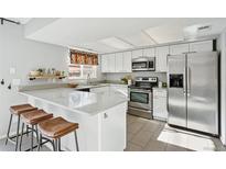 Modern kitchen with stainless steel appliances and breakfast bar at 12584 W Virginia Ave, Lakewood, CO 80228