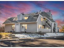 Gray multi-unit building with parking and landscaping at 8701 Huron St # 10-210, Thornton, CO 80260