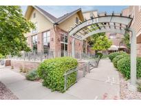 Inviting building exterior with landscaped grounds and covered walkway at 7931 W 55Th Ave # 112, Arvada, CO 80002