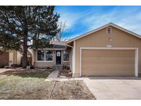 Tan house with attached garage and landscaping at 16812 E Mansfield Cir, Aurora, CO 80013