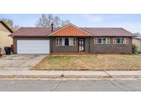 Brick ranch home with attached garage and mature landscaping at 14830 Robins Dr, Denver, CO 80239