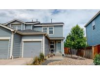 Two-story townhome with gray siding and a double car garage at 762 Mockingbird Ln, Brighton, CO 80601