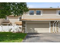 Tan two-story townhome with attached garage and small front yard at 3228 S Xanadu St, Aurora, CO 80014