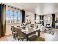 Modern dining area with a table and chairs, adjacent to a living room at 10251 E 62Nd Pl, Denver, CO 80238