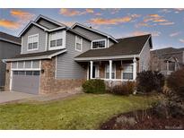Two-story house with gray siding, stone accents, and a landscaped lawn at 9362 Autumn Ash Ct, Highlands Ranch, CO 80126