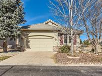 House exterior featuring a beige facade, attached garage, and landscaping at 6292 S Blackhawk Ct, Centennial, CO 80111