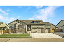 Two-story house with stone accents and a two-car garage at 11430 Kalispell St, Commerce City, CO 80022