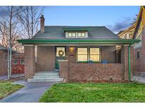 Brick home with green trim, inviting porch, and well-manicured lawn at 931 S York St, Denver, CO 80209