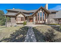 Two-story home with stone and wood siding at 6796 Timbers Dr, Evergreen, CO 80439