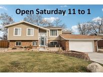 Tan two-story house with attached garage and landscaping at 5948 Routt St, Arvada, CO 80004