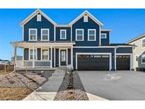 Two-story farmhouse-style home with a charming front porch and a three-car garage at 959 Eldorado Ln, Louisville, CO 80027