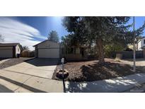 Ranch-style home with a two-car garage and mature landscaping at 15038 E Greenwood Pl, Aurora, CO 80014