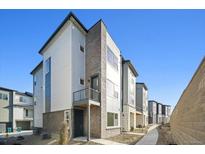 Modern three-story townhome with a balcony and attached garage at 461 Interlocken Blvd # 105, Broomfield, CO 80021
