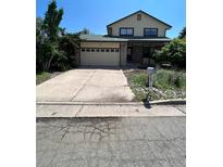 Two-story house with a stone facade, attached garage, and landscaped yard at 14190 E Gunnison Pl, Aurora, CO 80012
