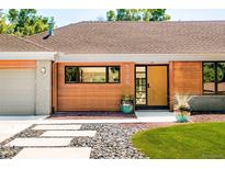 Mid-century modern home with wood siding, updated landscaping, and a welcoming front entry at 5730 E Princeton Ave, Cherry Hills Village, CO 80111