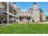 Tan multi-unit building with grassy area and walkway at 13657 E Yale Ave # A, Aurora, CO 80014