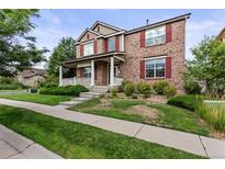 Two-story brick home with a front porch and landscaped yard at 8662 Eldridge St, Arvada, CO 80005