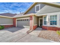 Exterior of charming townhome with brick and siding, attached garage, and landscaping at 8201 S Winnipeg Ct, Aurora, CO 80016