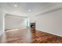 Living room with hardwood floors and a brick fireplace at 6420 S Dayton St # J06, Englewood, CO 80111