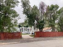 House exterior view with a large yard and mature trees at 1794 Caroline Ave, Fort Lupton, CO 80621