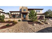 Two-story home with stone and stucco exterior, landscaping, and walkway at 4473 Echo Dr, Larkspur, CO 80118