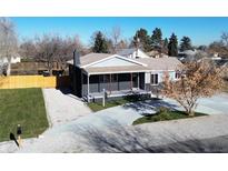 Newly renovated home with gray exterior, landscaped yard, and a spacious driveway at 6425 W Jefferson Pl, Lakewood, CO 80226