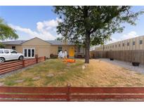 Ranch home with a small front yard, wooden fence, and landscaping at 262 S Bryant St, Denver, CO 80219