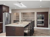 Spacious kitchen featuring granite countertops and stainless steel appliances at 8233 W 62Nd Pl, Arvada, CO 80004