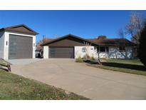 Ranch-style home with attached garage and landscaped yard at 2262 Ammons St, Lakewood, CO 80214