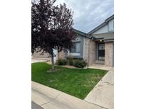 Brick home with a well-manicured lawn and mature tree at 2213 S Kingston Ct, Aurora, CO 80014