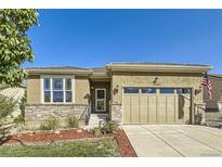 Tan house exterior with landscaping, two-car garage, and front porch at 16262 Red Mountain Way, Broomfield, CO 80023