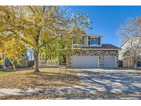 Two-story home with stone accents, three-car garage, and autumn leaves at 5504 E Burlington Dr, Castle Rock, CO 80104