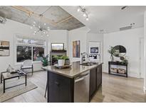 Modern kitchen with an island, stainless steel appliances, and exposed ductwork at 3301 Arapahoe Ave # 101, Boulder, CO 80303