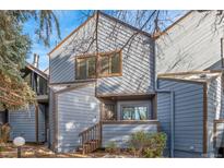 A charming townhome with a wood-toned front door and steps at 8971 W Yale Ave, Lakewood, CO 80227